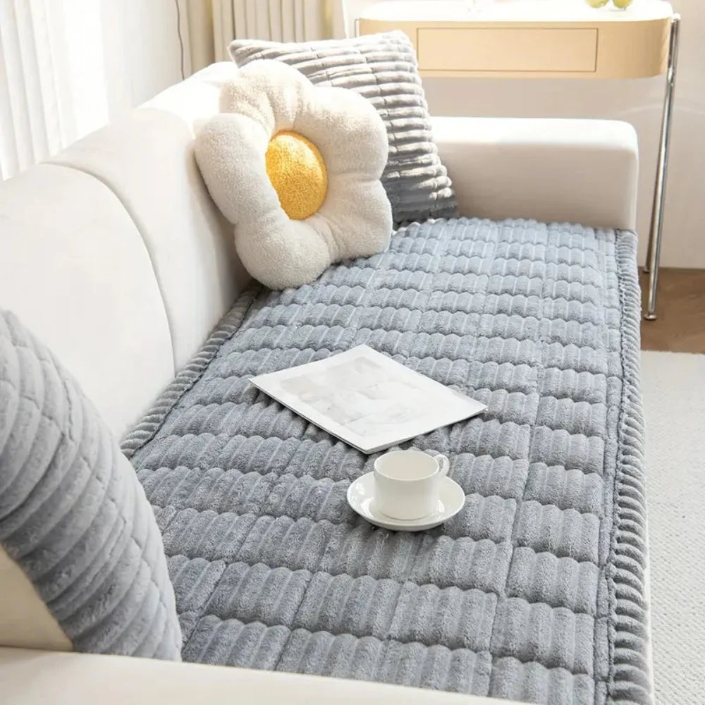 Plush flannel anti-slip sofa cover with pleated edges in a cozy living room setting, providing comfort and style while protecting furniture. 5